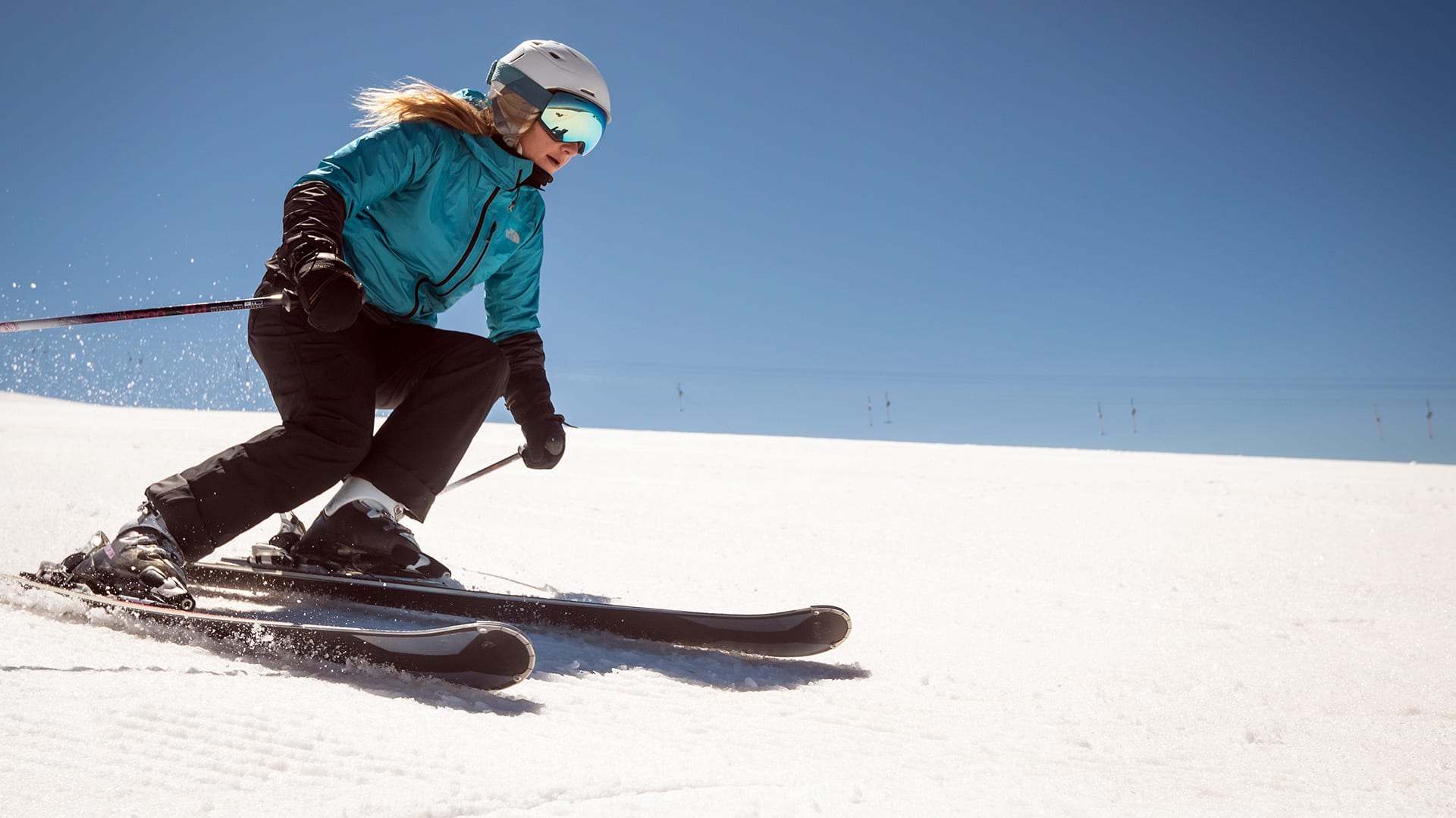 Skieuse sur une piste damée sous le soleil